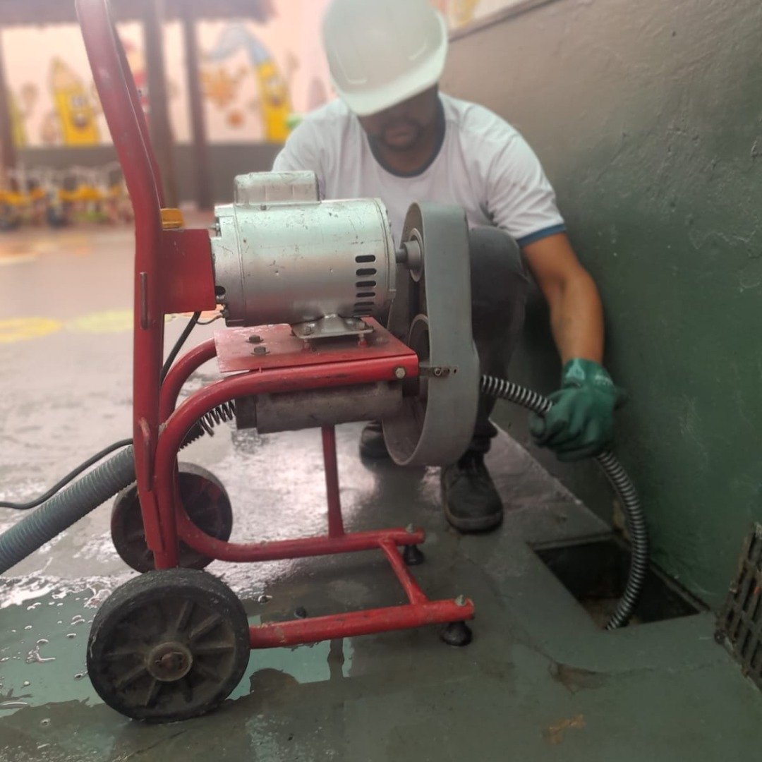 Profissional especializado em desentupimento com equipamento industrial